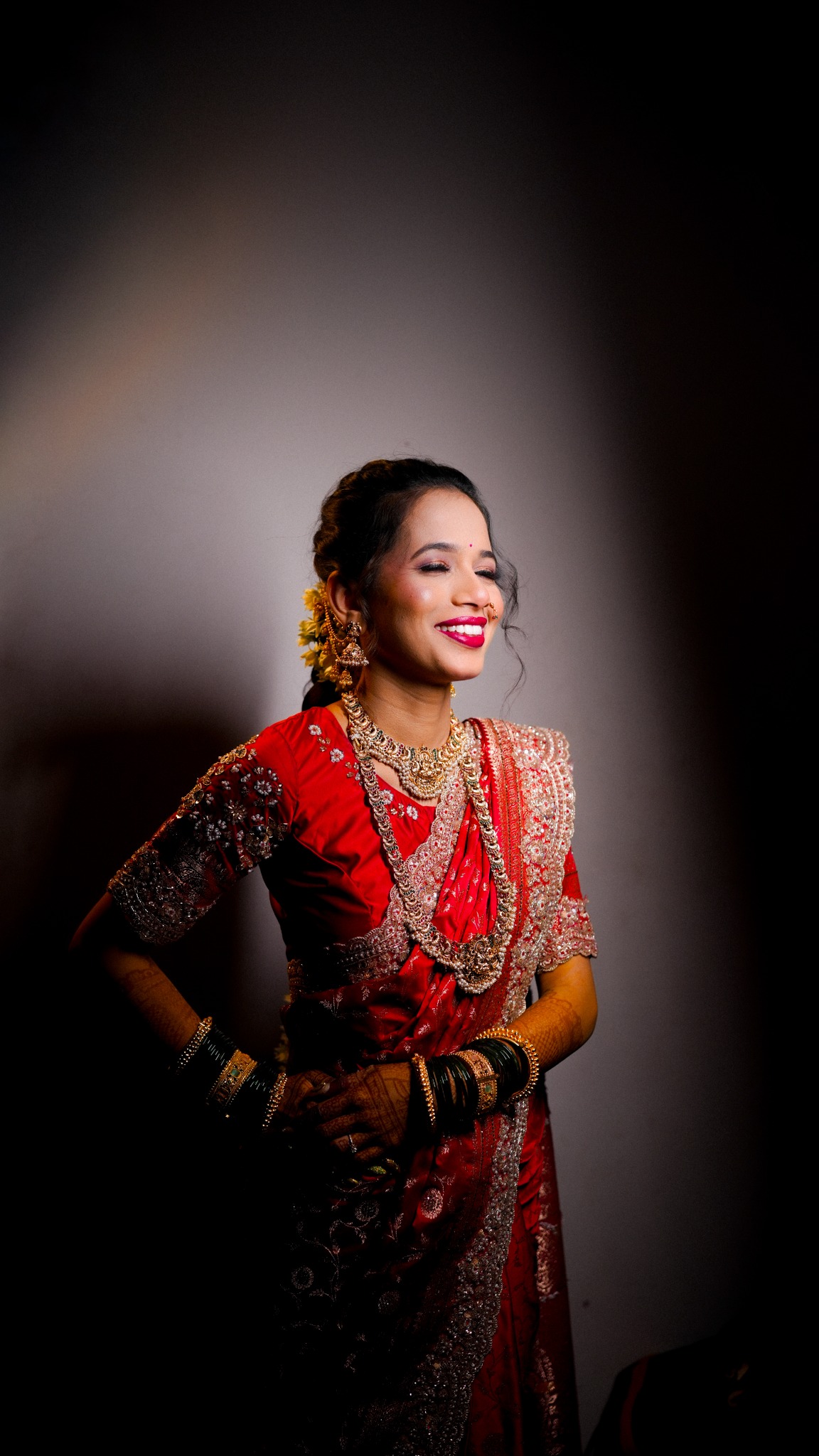 Bride in a red sari, photographed in soft studio light